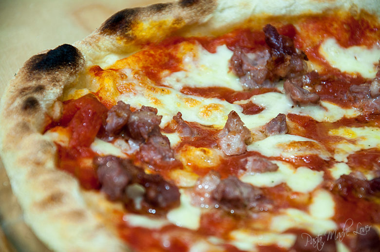 Pizza con pomodoro, salsiccia e mozzarella